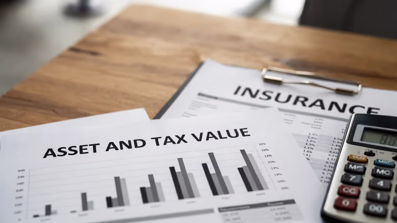 Estate value and tax calculation documents with life insurance policy on desk