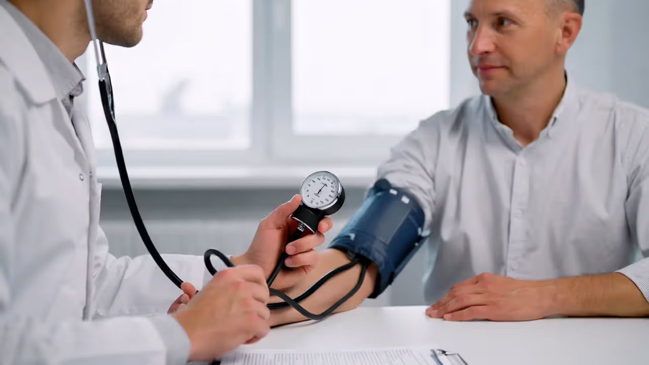 Medical professional checking blood pressure during insurance exam